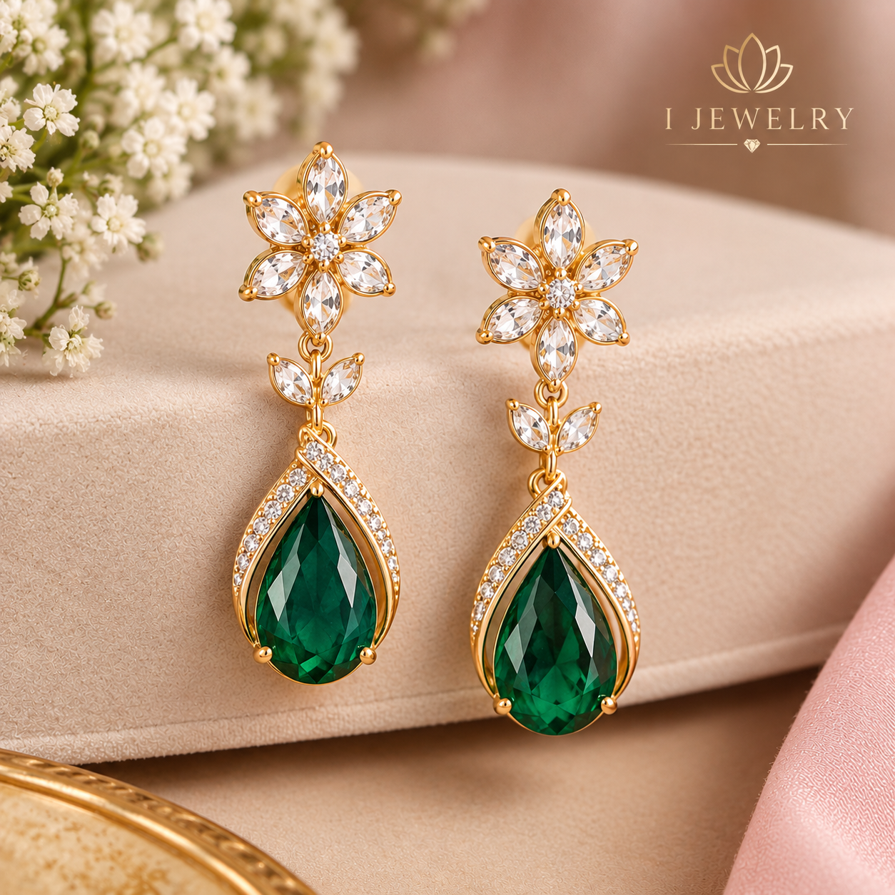 Elegant emerald green drop earrings with floral gold details.