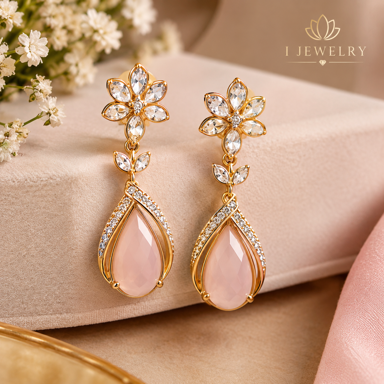 Elegant gold floral drop earrings with delicate pink teardrop stones.